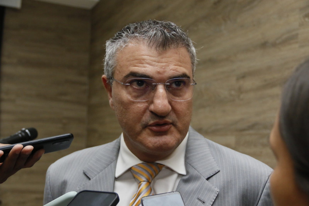 Procurador em reunião, discutindo lei contra trans no esporte.