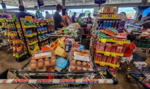 12/06/2026 - Brasília - Consumidores enfrentam longas filas nos caixas de um grande mercado atacadista para finalizar suas co
